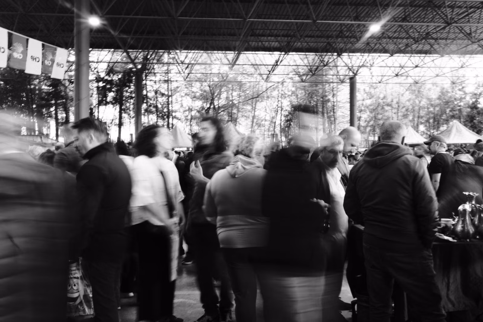 Dynamic black and white photo capturing a bustling urban outdoor market crowd.